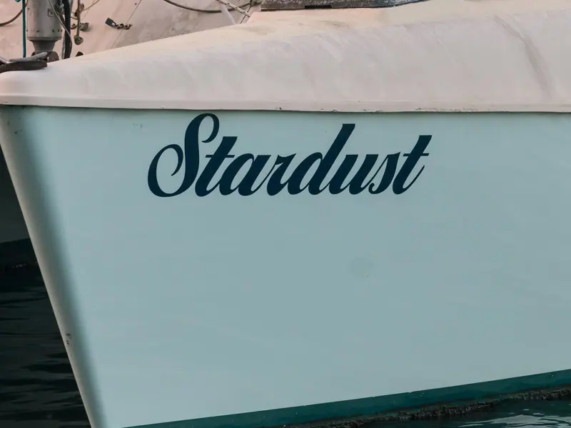 De naam Stardust op de romp van een zeilboot
